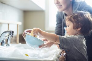 child-and-parent-washing-dishes-together